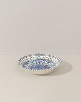 A ceramic decorative plate with a hand-painted geometric pattern predominantly in blue and white colors.