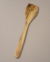 A large spatula made of natural olivewood with a smooth finish and characteristic wood grain patterns.