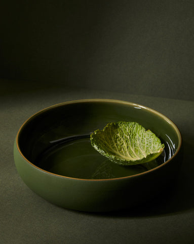 A beige Stoneware Shallow Serving Bowl with a capacity of 60 oz, displayed against a neutral background with a small amount of food items like pasta or noodles in it to showcase its size and shape.