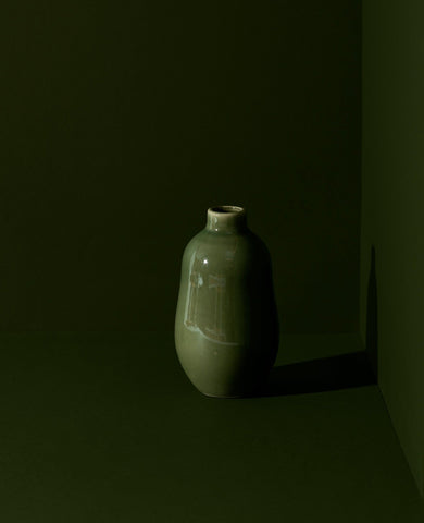 Matte green handmade stoneware vase with a minimalistic design, displayed against a matching green background for a monochromatic, modern aesthetic.