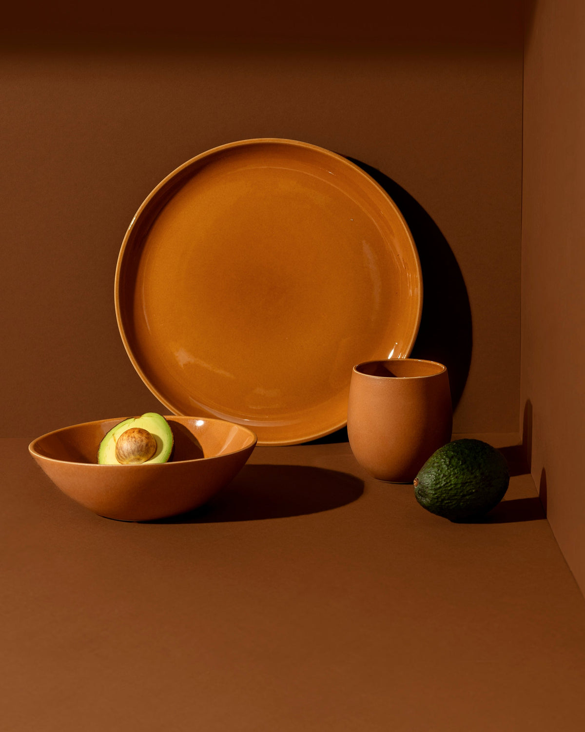 A set of white stoneware dinnerware including a flat salad plate, a dinner bowl, and a mug.