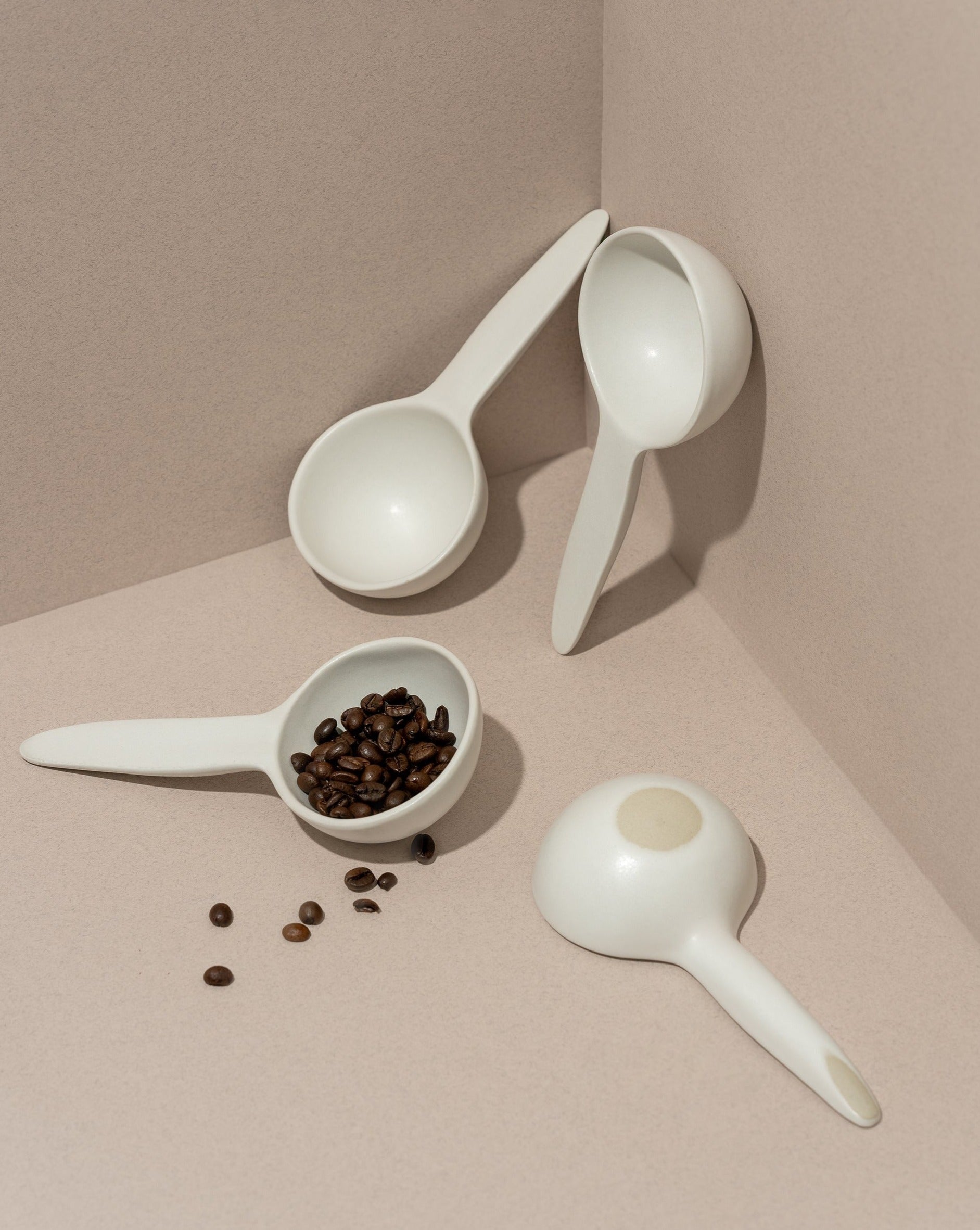 A stoneware bowl with a spoon shape, placed on a table with some food items, used as a serving dish for a meal.