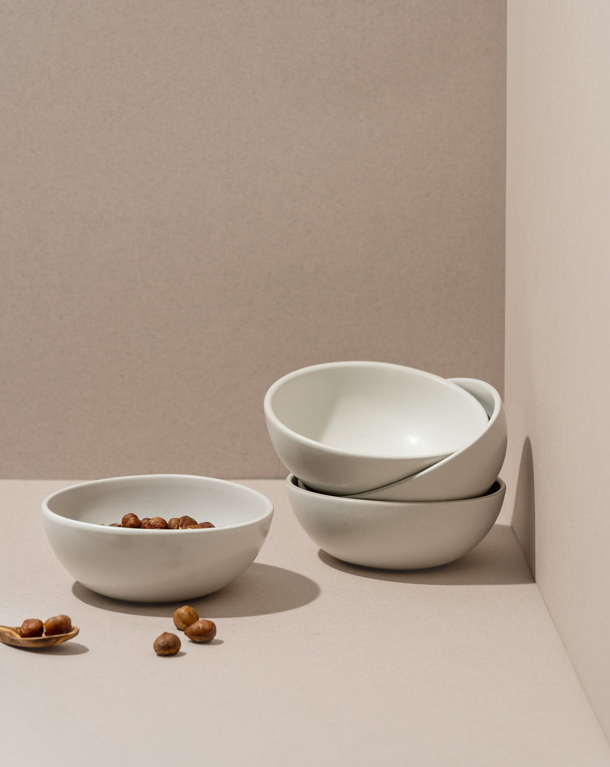 A white stoneware cereal bowl is displayed against a neutral background. The bowl appears modern and simple in design with a matte finish.