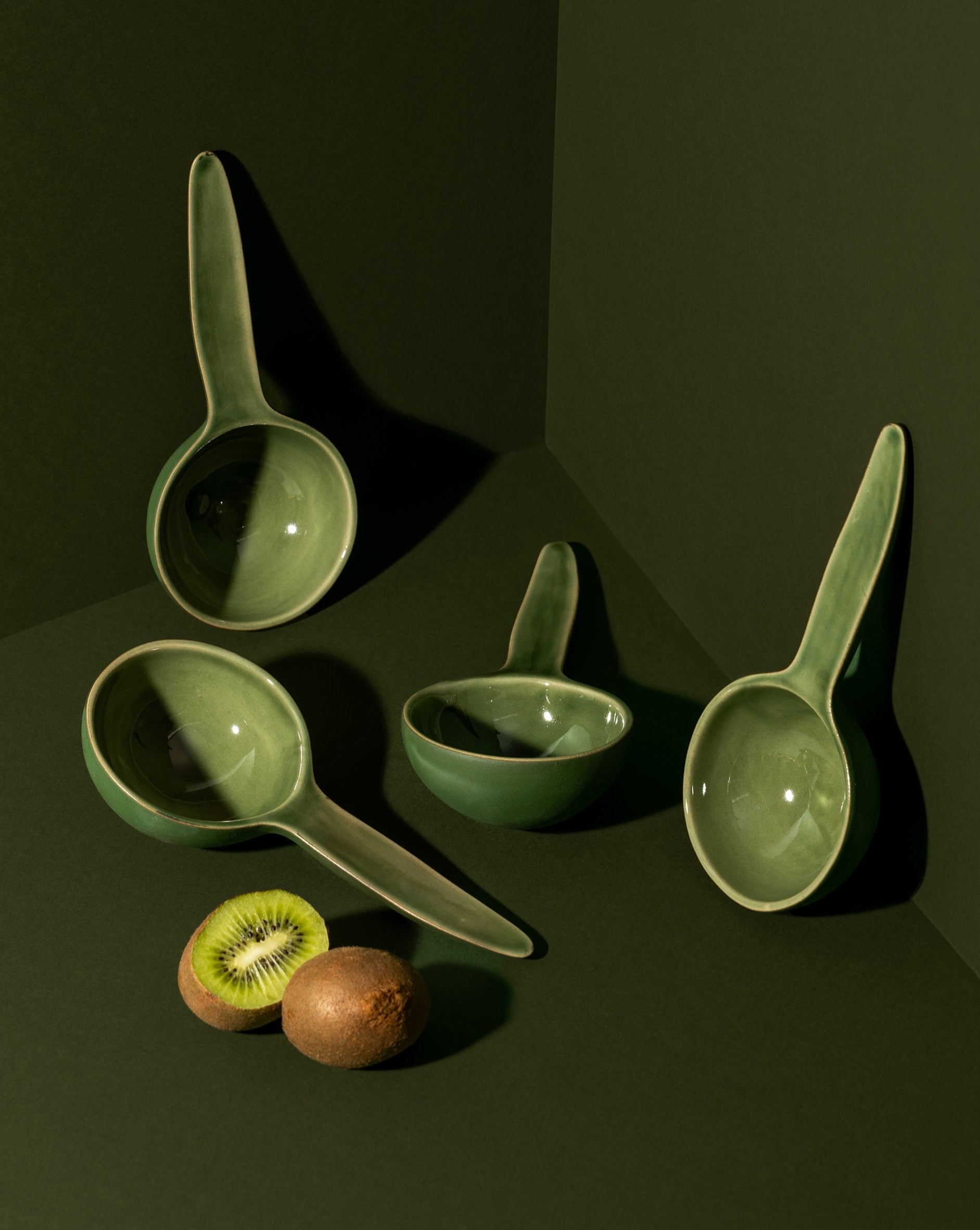 A stoneware bowl with a spoon shape, placed on a table with some food items, used as a serving dish for a meal.
