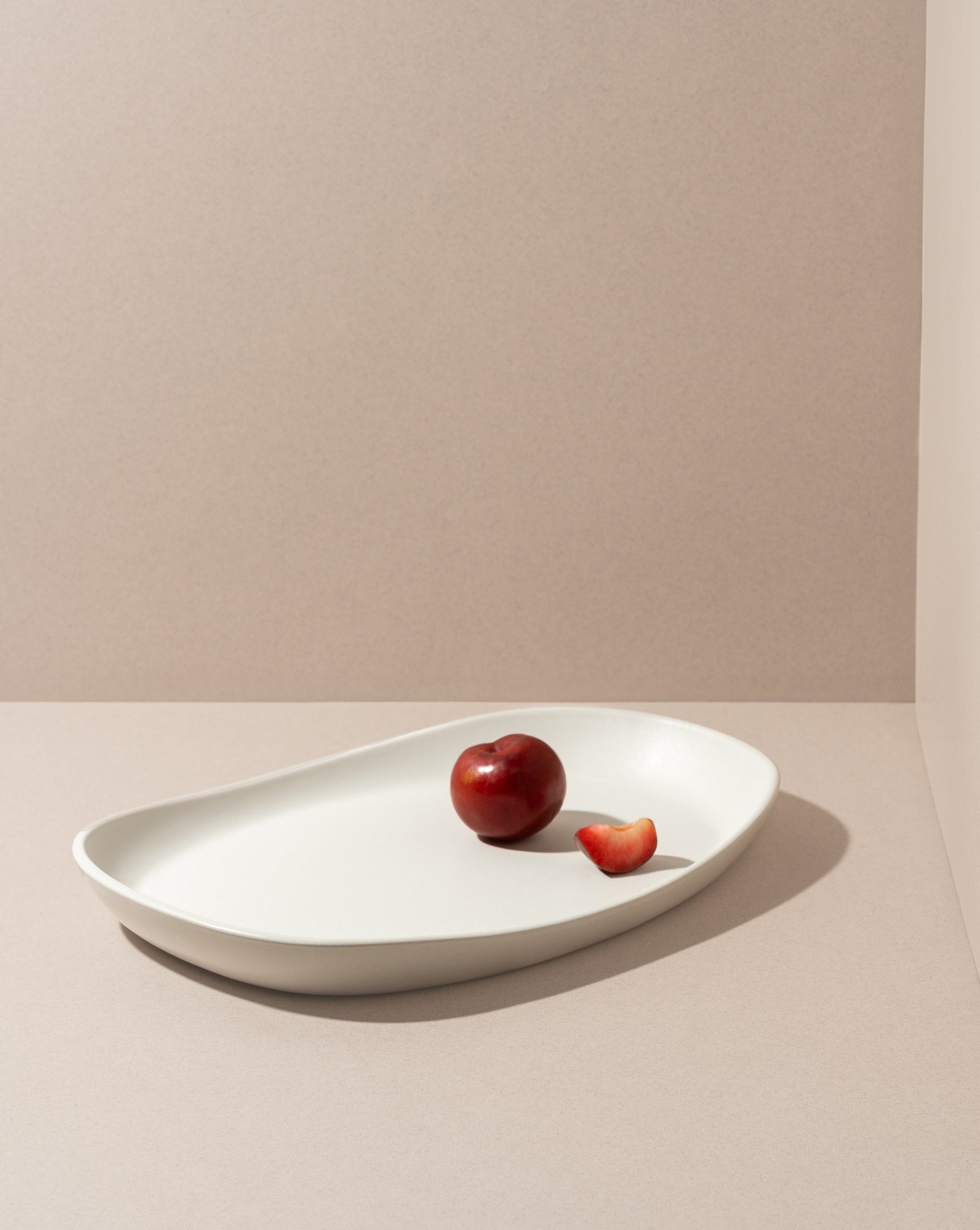 Mini stoneware serving platter with a selection of pastries and blackberries on a kitchen countertop.