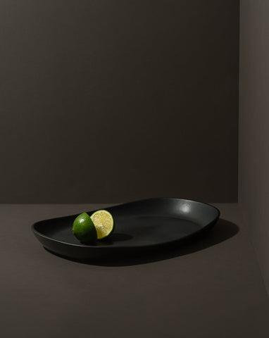 Mini stoneware serving platter with a selection of pastries and blackberries on a kitchen countertop.