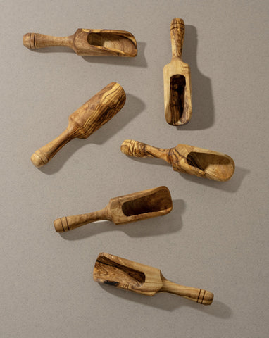 A collection of wooden scoops of various sizes, displayed against a neutral background.