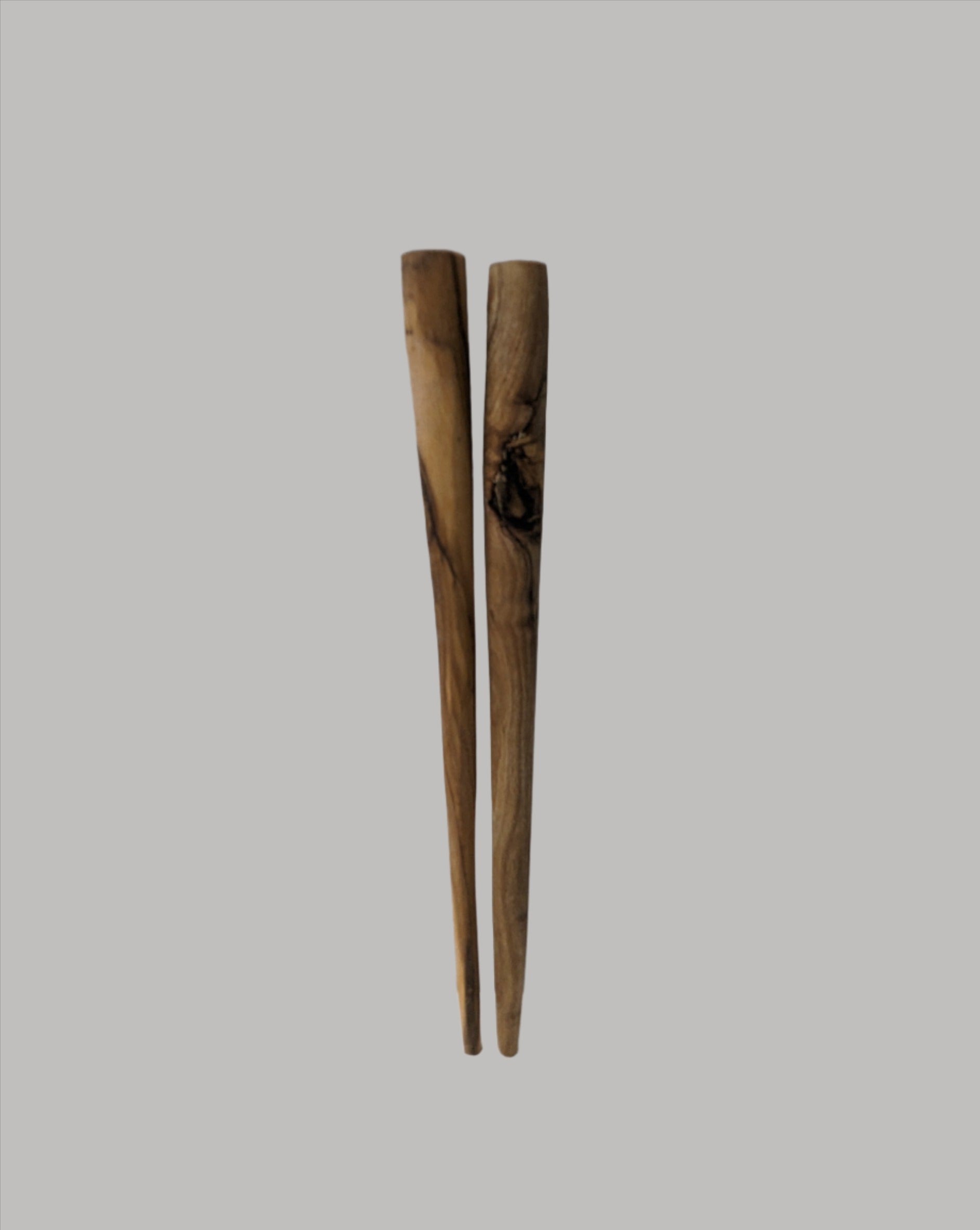 A pair of wooden chopsticks displayed on a white background, highlighting their simple design and natural wood texture.